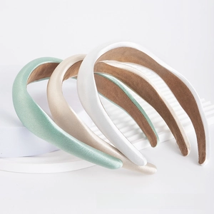 Detailed macro view of padded satin headbands in mint, champagne, and pearl colors