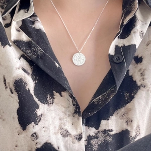 Minimalist 925 sterling silver compass necklace with textured round pendant on model