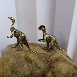 Retro bronze-plated dinosaur figurines set on natural rock for home desk decor