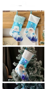 Close-up of blue LED Christmas stockings with snowman and Santa motifs on a fireplace
