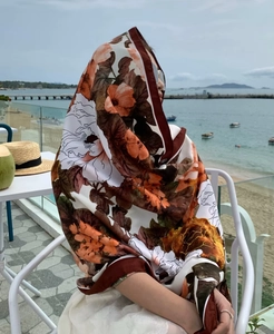 Detail of a floral print sun-protection shawl worn at the beach for summer vacation