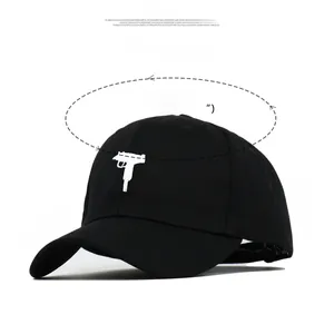 Detail view of black baseball cap showing handgun embroidery and specific size dimensions