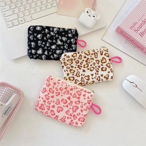 Detailed overhead view of canvas heart print pouches for coins and earphones in three colors