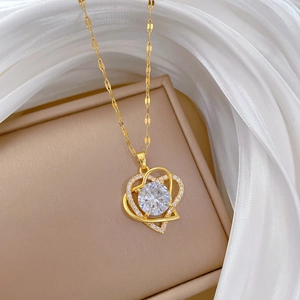 Close-up of double layer gold heart pendant necklace with zircon on white silk background