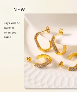 Macro detail of gold C-shape stud earrings with sparkling pavé cubic zirconia