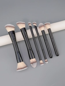 Detailed view of dual-ended professional makeup brushes with gradient fibers on white stand