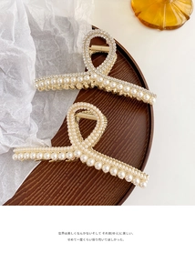 Gros plan de pinces à cheveux dorées avec rangées de perles et strass scintillants