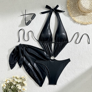 Ensemble bikini noir métallique avec maillot de bain ajouré et paréo assorti posé