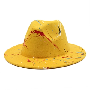 Detailed view of yellow wool felt fedora featuring creative colorful paint splatter