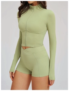 Detail of sage green yoga jacket featuring a stand collar and high-waisted crossover shorts