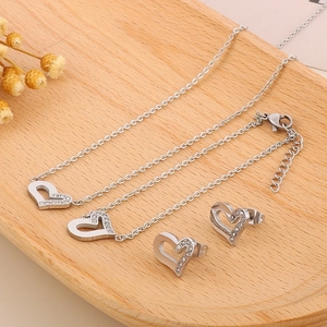 Dettaglio del set di gioielli a cuore in argento con strass su vassoio in legno