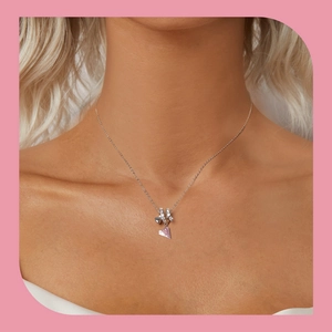 Close-up of S925 silver necklace with pink enamel plane and heart charms on neck