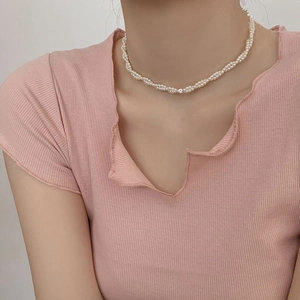 Elegant woven pearl necklace with cubic zirconia accent on model's neck