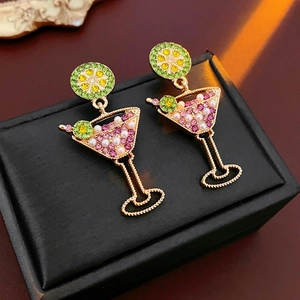Detail of vintage cocktail glass earrings with pink rhinestones and pearls on a black box