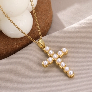 Detail of cross pendant featuring high-quality white pearls on a gold-plated link chain