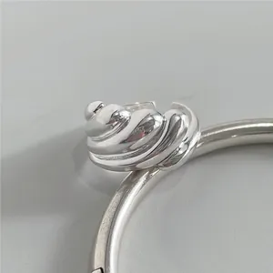 Macro shot of polished silver ring with a sophisticated 3D spiral sea shell texture