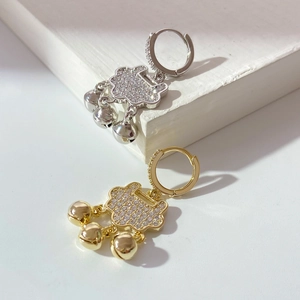 Detail view of gold and silver padlock earrings with micro-inlaid zircons and bells
