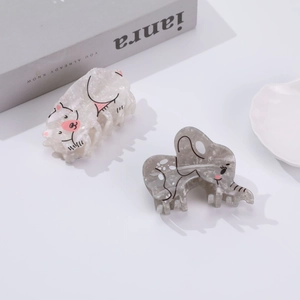 Cute elephant acetate hair claw clips in white and grey colors on a white minimalist desk