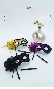 Three sequined masquerade masks with side flowers and feathers on handheld sticks