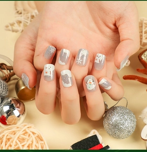 Detail of Christmas press-on nails featuring grey, white, and silver snowflake snowman designs