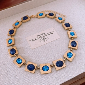 Detailed macro view of vintage gold necklace with blue marble resin and faceted crystals