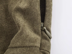 Detail eines verdeckten Reißverschlusses und Wildlederstruktur am olivgrünen Kleid