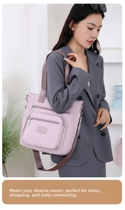 Detail view of purple nylon tote bag with multiple zipper pockets and wide straps