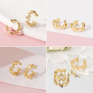 Vistas detalladas de ear cuffs dorados ondulados con diseño geométrico moderno