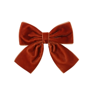 Detailed macro view of the premium velvet texture on the caramel red ribbon hair clip