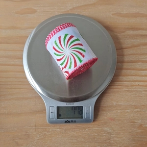 Weihnachtsband mit Zuckerstangen-Druck auf Waage zeigt Gewicht von 110 Gramm