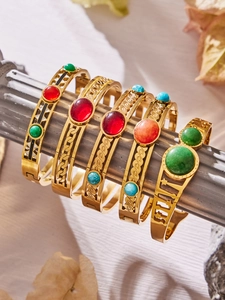 Detailed macro view of gold-plated bracelets featuring natural stone inlay and Roman numerals