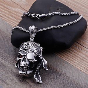 Détail d'un pendentif crâne de pirate en argent avec pierre précieuse rouge