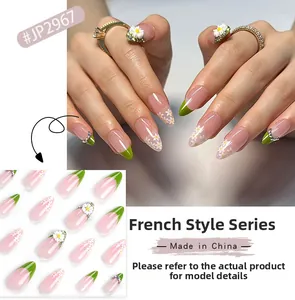 Macro shot of green French tip press-on nails with white daisy and rhinestone details