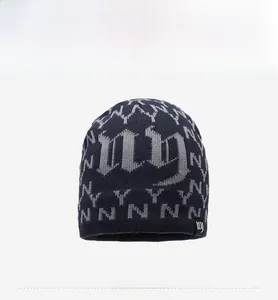 Detail of navy knit beanie featuring grey gothic NY logo patterns and ribbed texture