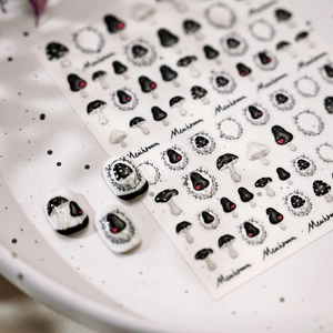 Retro hand-drawn mushroom nail art stickers with red hearts on white ceramic plate