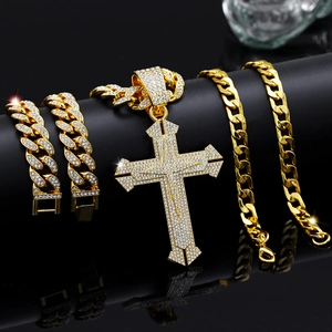 Close-up of golden iced out cross pendant and Cuban link chain set with box clasp