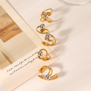 Artistic layout of two-tone gold and silver stainless steel rings on a minimalist background