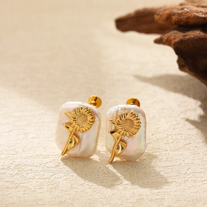 Detailed macro view of Baroque pearl earrings with golden sunflower relief and screw-back clips