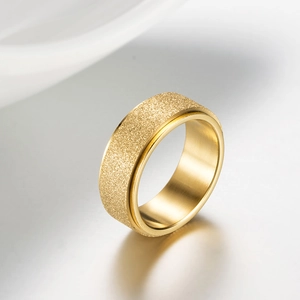 Macro shot of gold spinner ring featuring sandblasted finish and polished inner band