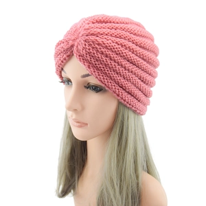 Detailed close-up of pink chunky knit bohemian beanie with spiral texture on a model head