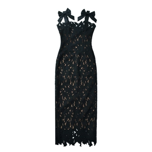 Detailed close-up of intricate black lace floral pattern and bow straps on the dress
