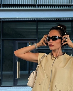 Detail einer beige Utility-Weste mit Reißverschluss, Kordelzug und lässigem Streetwear-Stil