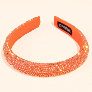 Macro detail of handmade bright orange headband with sparkling AB rhinestones