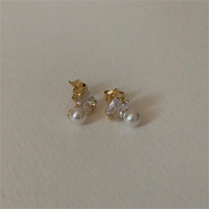 Detailed view of 925 silver stud earrings with square zircon and white pearl accents