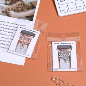 Detail view of rose gold and silver watch strap charms with rhinestones and heart pendants