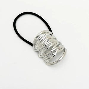 Detail view of a silver hollowed metal cylinder decoration on a high elastic black hair tie