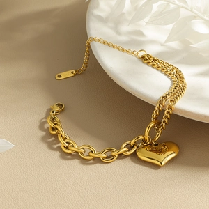 Detailed macro view of asymmetric golden stainless steel heart bracelet chain design