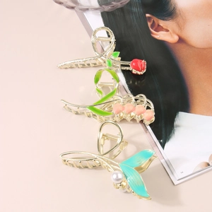 Detail of tulip and rose enamel metal hair claws with pearl accent on pink background