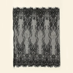 Detailed view of black lace fabric featuring intricate baroque floral patterns and wavy edges