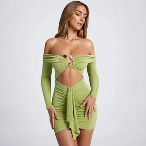 Détails de robe moulante verte avec anneau métallique et découpes à la taille devant